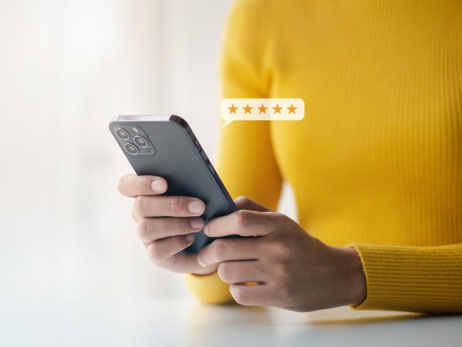 person using phone giving 5 stars in review