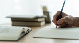 hand holding pen writing on paper